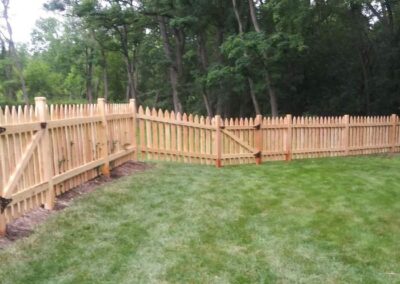 A wood fence and gate on a large property